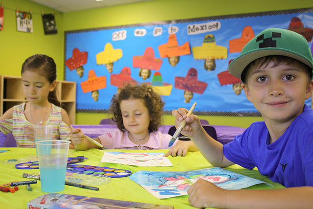 Children painting at Pear Tree summer camp painters palette theme